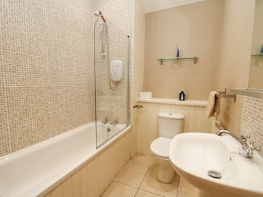 A bathroom with a bathtub shower toilet and sink at Bwthyn Bach in Newport