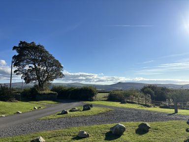 A view of mountains and a tree in a landscape at Y Cwtch Newport