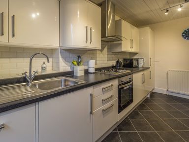 A kitchen with a sink stove oven microwave and cabinets at The Old Exchange in Corbridge near Hexham