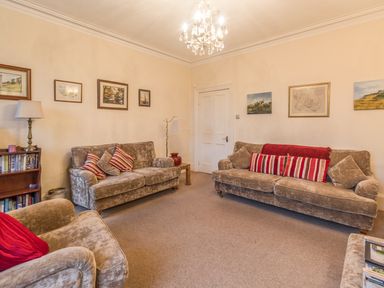 A living room with three sofas and framed pictures on the walls at The Old Exchange in Corbridge near Hexham