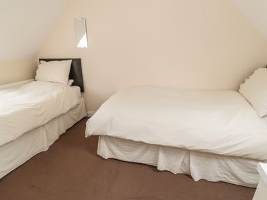 A bedroom with two single beds with white bedding at No 1 Low Hall Cottages Scalby near Scarborough
