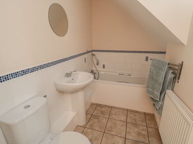 A bathroom with a toilet sink bathtub towel rack and radiator at No 1 Low Hall Cottages Scalby near Scarborough