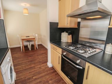 A kitchen with wooden floor and dining table with four chairs at No 2 Low Hall Cottages Scalby near Scarborough