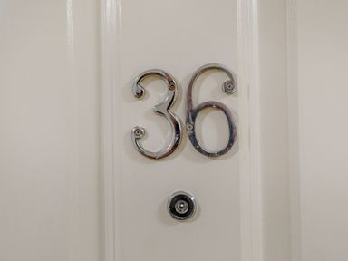 A white door with metallic number 36 and a doorbell at Perriwinkle The Bay near Filey