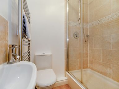 A bathroom with a sink faucet a toilet a towel rack and a tiled shower at Perriwinkle in The Bay near Filey