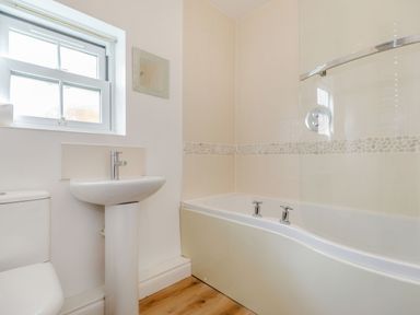 A bathroom with a toilet sink and bathtub with shower screen at Perriwinkle The Bay near Filey