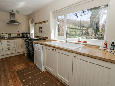 A kitchen with a sink and oven at Penlone Cottage in Rhayader