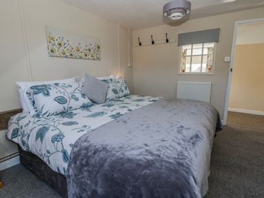 A bedroom with a bed and wall art at Penlone Cottage in Rhayader