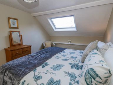 A bedroom with a bed and a mirror at Penlone Cottage Rhayader