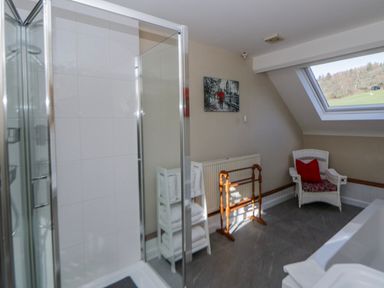 A bathroom with a shower and a bathtub at Penlone Cottage in Rhayader