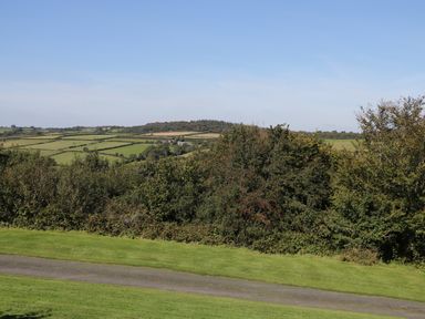 A rural landscape with hedges trees and a road at Middle Barn in Launceston