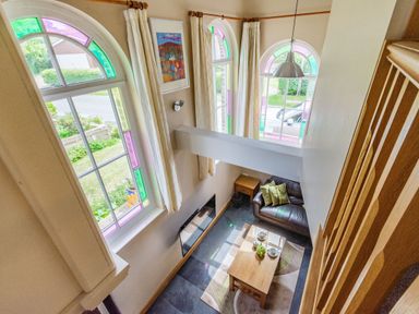 A two story living room with arched windows and a coffee table at The New Chapel in Great Hatfield near Hornsea