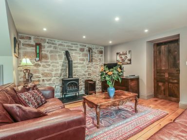 A living room with a sofa and a coffee table at The Lodge Farm Barn Deepdean near Ross-on-Wye
