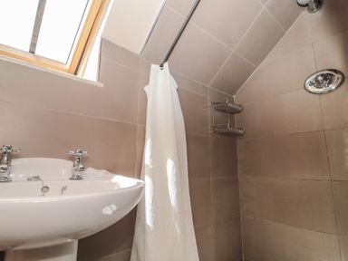 A bathroom with a basin and shower at The Lodge Farm Barn in Deepdean near Ross-on-Wye
