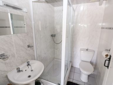 A bathroom with a sink toilet and shower enclosure at Ffynnon Tom in Trefin near St Davids
