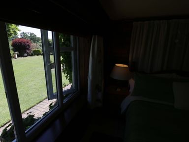 A bedroom with a window overlooking a garden at Severn Bank Lodge Astley Burf near Stourport-on-Severn
