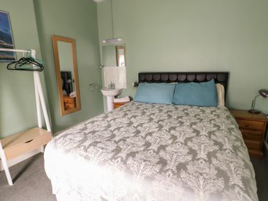 A bedroom with a bed and bedside table at Halford Hill in Llanberis