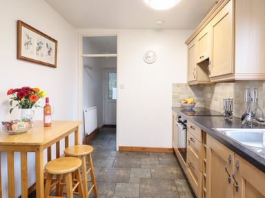 A kitchen with a table and stools at Bryn Re in Trawsfynydd near Llan Ffestiniog and Dolgellau