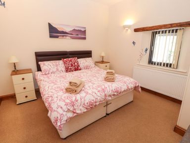 A bedroom with a double bed and bedside tables with lamps at The Hayloft in Newlands near Braithwaite and Keswick