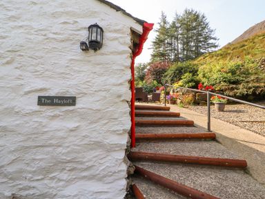 Steps leading to a garden area with chairs and flowers at The Hayloft in Newlands near Braithwaite and Keswick