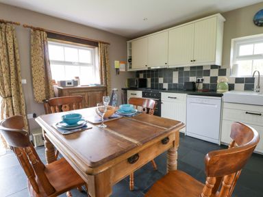 A kitchen with a wooden table and chairs at Blaenffynnon Bach Trelech near Crymych