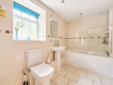 A bathroom with a toilet sink and bathtub with shower at Old Rectory Cottages Aberhafesp near Newtown