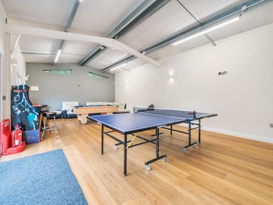 A games room with a ping pong table pool table arcade game and seating at Old Rectory Cottages Aberhafesp near Newtown