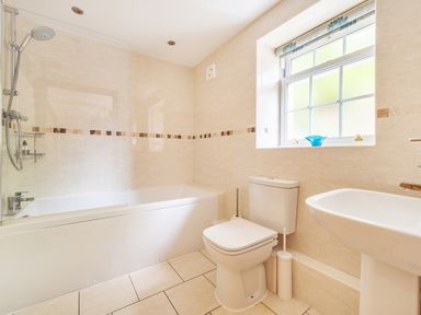 A bathroom with a white bathtub shower toilet and sink at Old Rectory Cottages Aberhafesp near Newtown