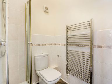 A bathroom with a toilet shower enclosure and a heated towel rail at Menai View in Llanfairpwllgwyngyll near Beaumaris