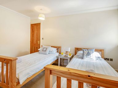 A bedroom with two single beds and a small table with a lamp and drinks between them at Menai View in Llanfairpwllgwyngyll near Beaumaris