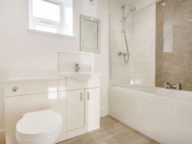 A bathroom with a white toilet sink cabinet bathtub and shower at Menai View in Llanfairpwllgwyngyll near Beaumaris