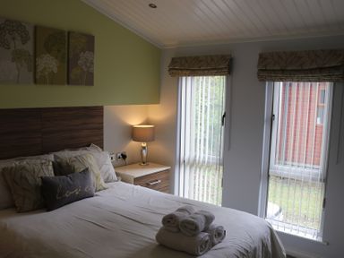 A bedroom with a bed and bedside table at High View Lodge near Troutbeck Bridge