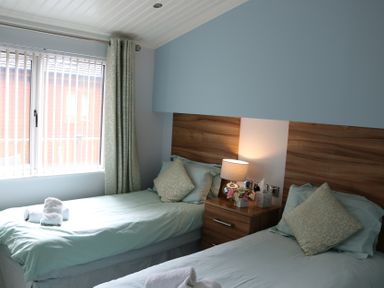 A bedroom with two single beds and a window at High View Lodge White Cross Bay near Troutbeck Bridge