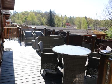 An outdoor sitting area with a table and chairs at High View Lodge White Cross Bay near Troutbeck Bridge