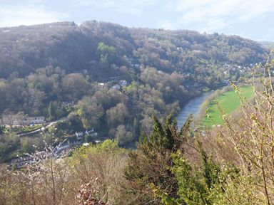A river running through a wooded valley with houses and green fields at The Old Dairy in Newnham-on-Severn