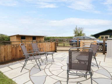 A patio area with chairs and a table at The Nook in Royal Wootton Bassett