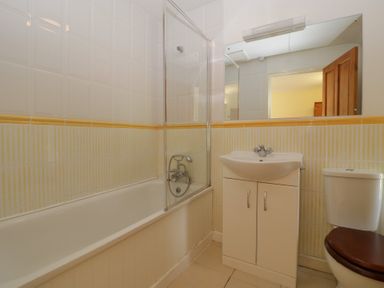 A bathroom with a bathtub shower sink cabinet toilet and a mirror at Wheelbarrow Cottage Stoke Prior near Leominster