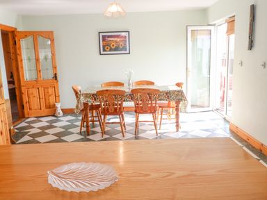 A dining room with wooden table and chairs on black and white checkered floor at Bluebell House and Gardens Gurteenulla near Ballydehob County Cork