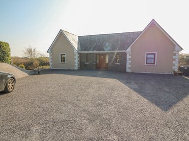 A house with gravel driveway and car parked in front at Bluebell House and Gardens Gurteenulla near Ballydehob County Cork