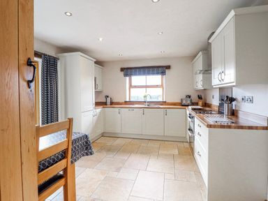 A kitchen with a table and chairs at Briws and 963354 together they sleep 35