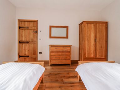 A bedroom with two beds and wooden furniture at Briws and 963354 together they sleep 35