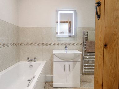 A bathroom with a bathtub and sink at Briws and 963354 together they sleep 35