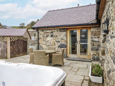 An outdoor space with a table and chairs near the stone wall at Briws and 963354 together they sleep 35