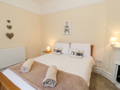 A bedroom with a double bed with pillows and rolled towels at The Farm House in Bala