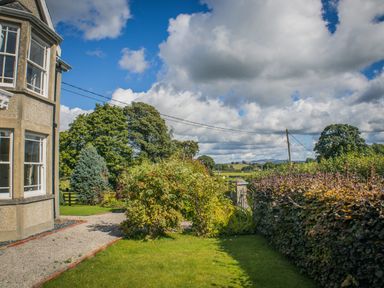 A garden with plants and trees at The Farm House in Bala