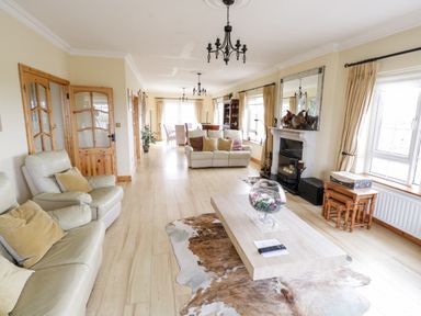 A living room with sofas coffee table fireplace and dining table at Shraigh Beach in Belmullet County Mayo