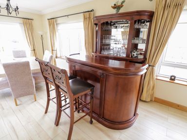 A dining room with a wooden bar counter and two bar stools at Shraigh Beach in Belmullet County Mayo