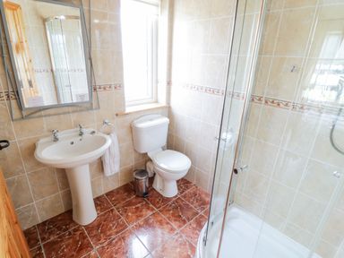A bathroom with a pedestal sink toilet shower and mirror at Shraigh Beach in Belmullet County Mayo