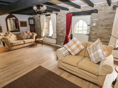 A living room with sofas and a coffee table at Maesgwyn in Bridell near Cardigan
