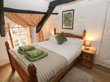 A bedroom with a bed and bedside table at Maesgwyn in Bridell near Cardigan